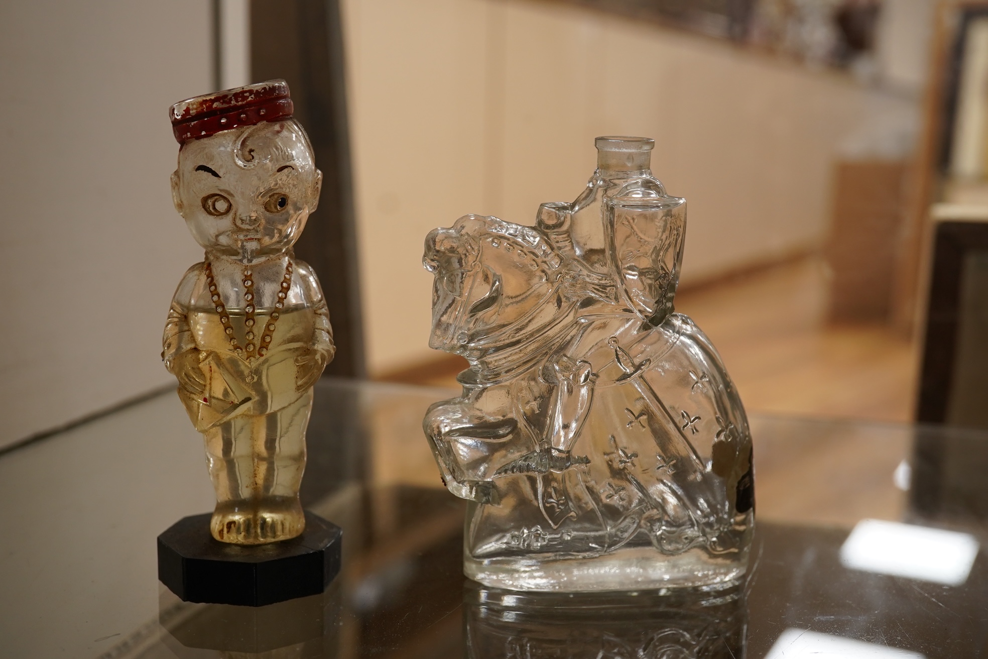 A collection of sundry items to include novelty glass bottles, devil pots and ceramic military caps